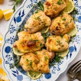 Square overhead shot of roasted lemon chicken on a platter.