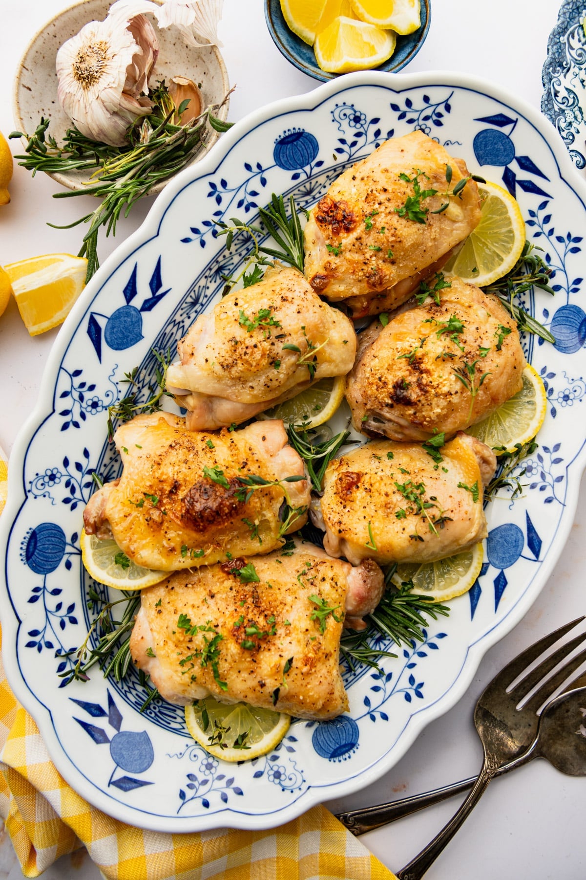 Overhead image of a blue and white platter full of roasted lemon chicken.