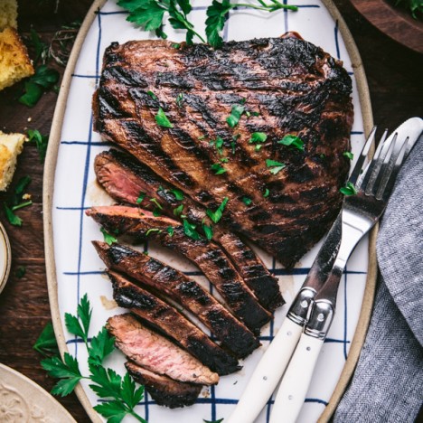 Close overhead image of sliced grilled flank steak on a serving platter
