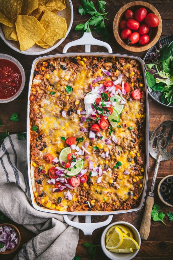 Overhead shot of a pan of mexican casserole on a wooden table in a white dish