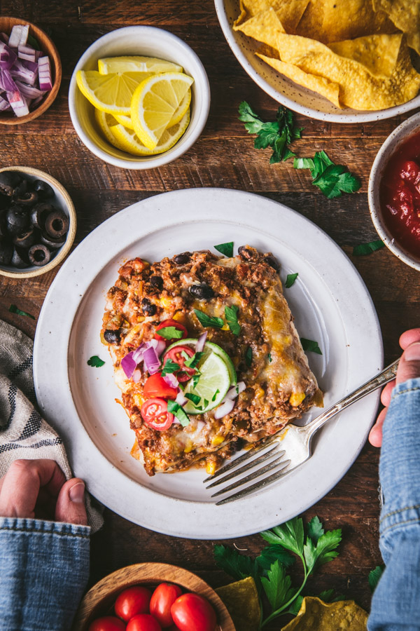 Overhead shot of a plate of mexican lasagna on a wooden table