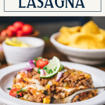 Side shot of a slice of mexican lasagna on a white plate with text title box at top
