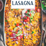 Overhead image of a pan of mexican lasagna in a white dish with text title overlay