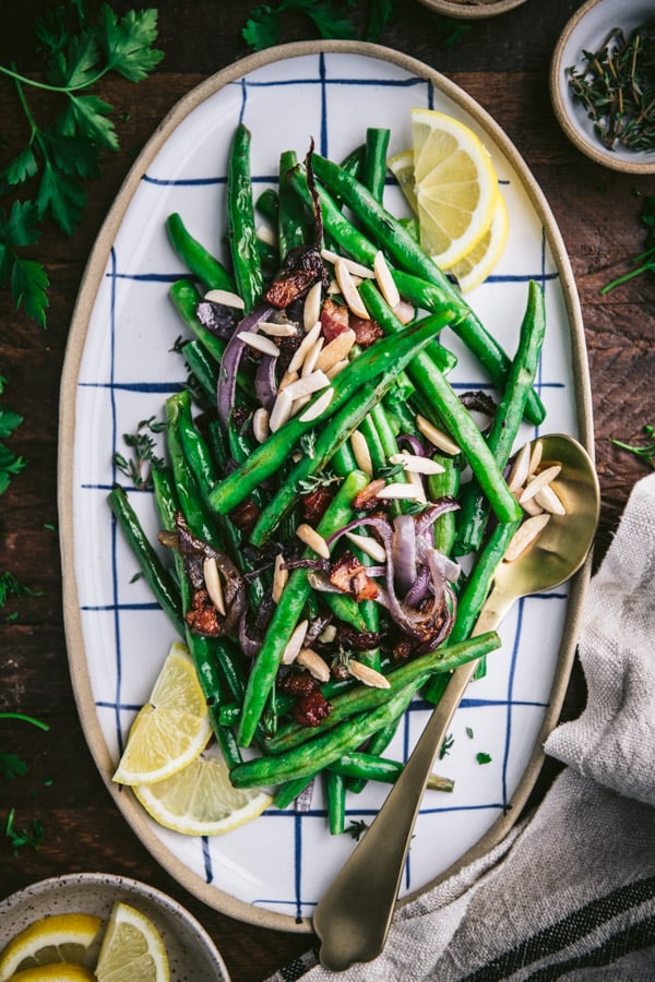 Overhead shot of a tray of roasted green beans on a wooden table