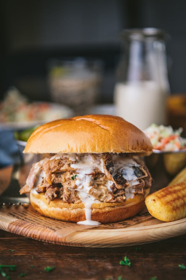 Close up side shot of a slow cooker pulled pork sandwich with white bbq sauce