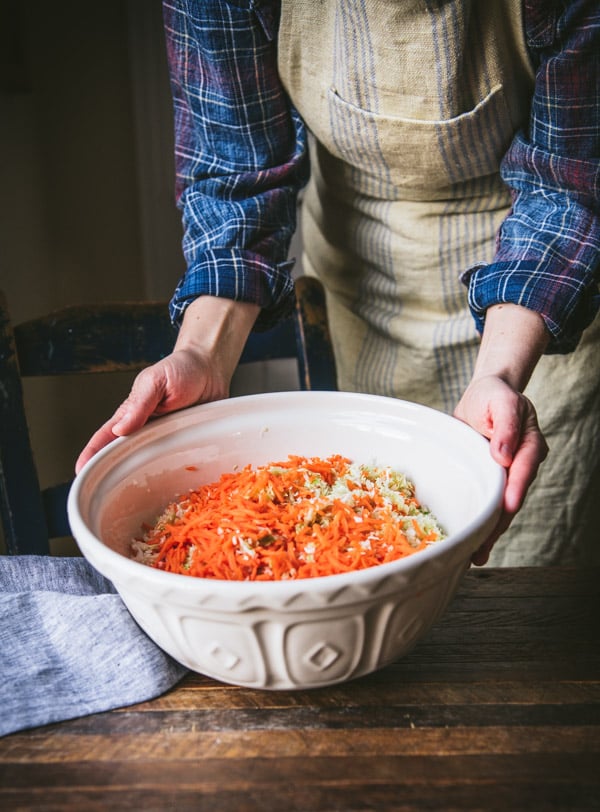 Chopped cabbage and carrots in a large white bowl