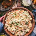 Hands holding a big wooden bowl of the best traditional coleslaw recipe