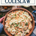 Overhead shot of hands holding a bowl of traditional coleslaw with text title box at top