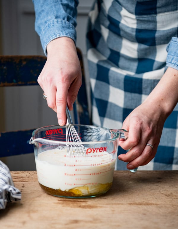 Whisking milk egg and other wet ingredients in a glass measuring cup