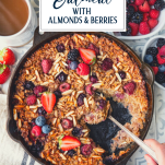 Spooning out baked oatmeal with almonds and berries and text title overlay