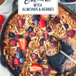 Close up shot of a cast iron skillet full of baked oatmeal with text title box at top