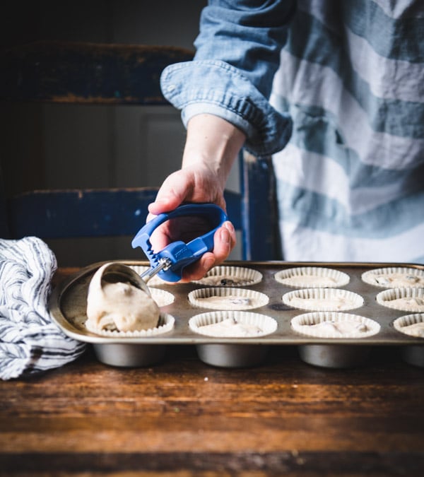 Scooping batter into a muffin tin