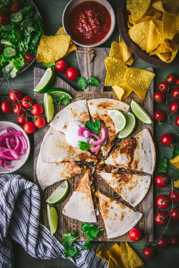 Overhead shot of the best chicken quesadilla recipe cut into wedges and served on a wooden board.
