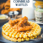 Close up side shot of a plate of crispy fried chicken and waffles with text title overlay