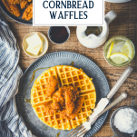Overhead shot of chicken and waffles recipe on a wooden table with text title overlay