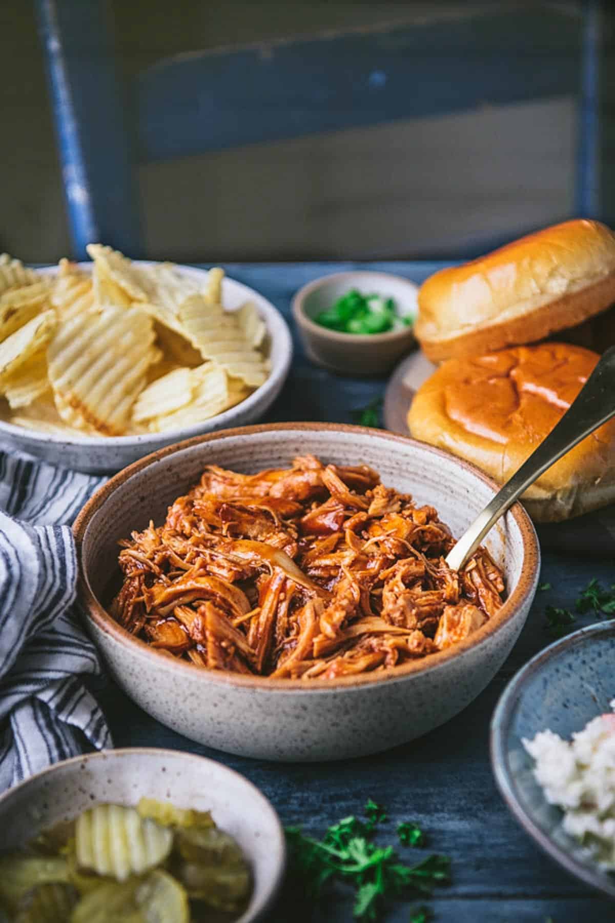 Side shot of a bowl of crock pot pulled bbq chicken.