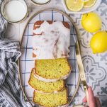 Hands slicing a loaf of lemon poppy seed bread