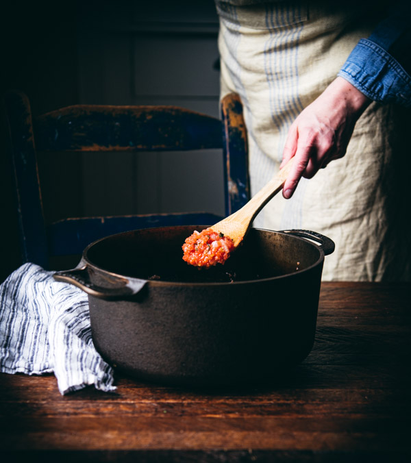 Process shot showing how to make pomodoro sauce in a Dutch oven