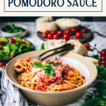 Side shot of a bowl of pasta pomodoro sauce with text title box at top