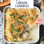Hands serving a spoonful of spinach artichoke chicken casserole with text title overlay