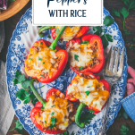 Overhead shot of hands holding a platter of stuffed peppers with rice and text title overlay