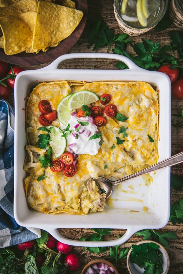 Overhead image of an easy chicken enchilada casserole in a white baking dish