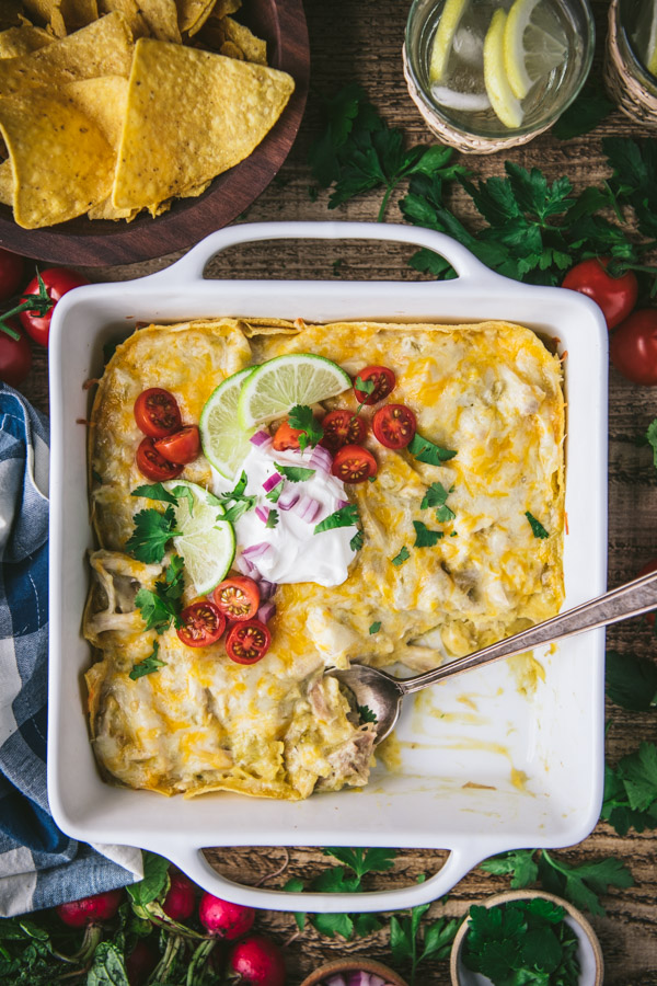Overhead shot of a pan of chicken enchilada casserole with green chiles and sour cream