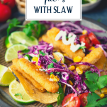 Side shot of fried crispy fish tacos with slaw and text title overlay