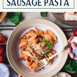 Overhead shot of a hand eating a bowl of sausage pasta with text title box at top