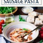 Side shot of a bowl of creamy sausage pasta on a table with text title box at top