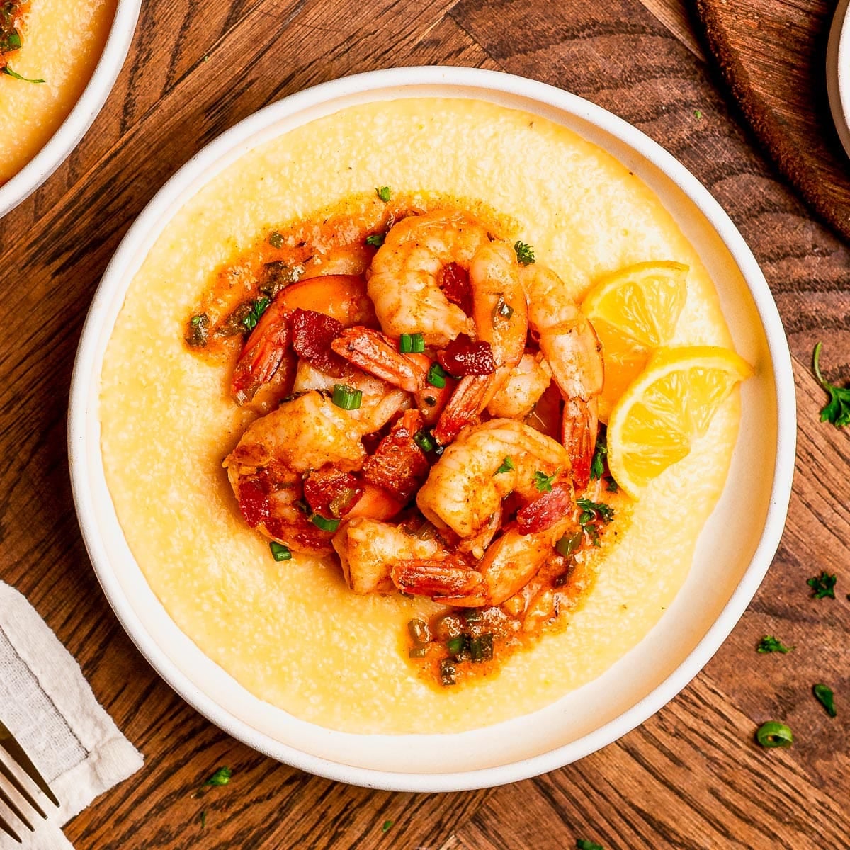 Square overhead shot of a plate of the best Southern shrimp and grits recipe.
