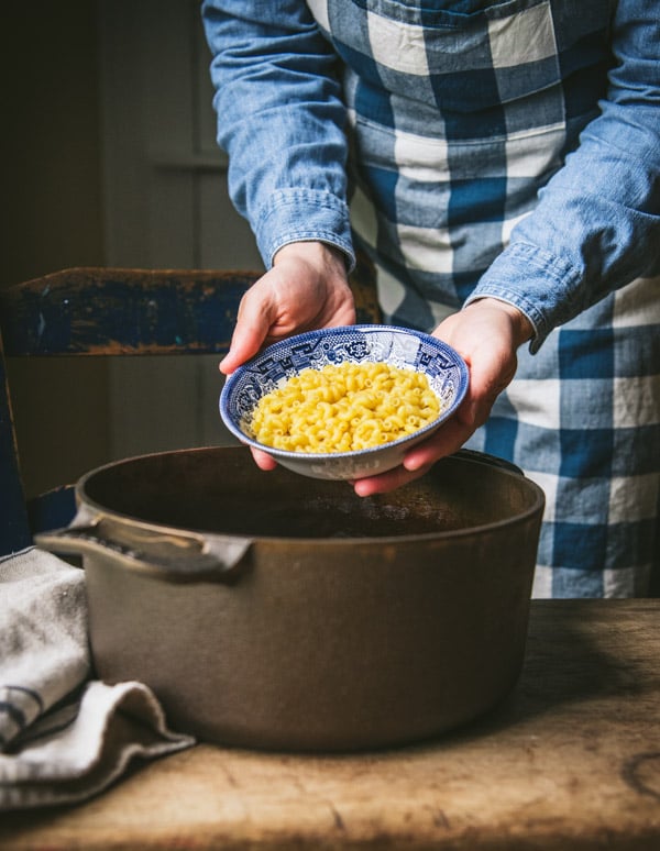 Adding uncooked macaroni to a skillet