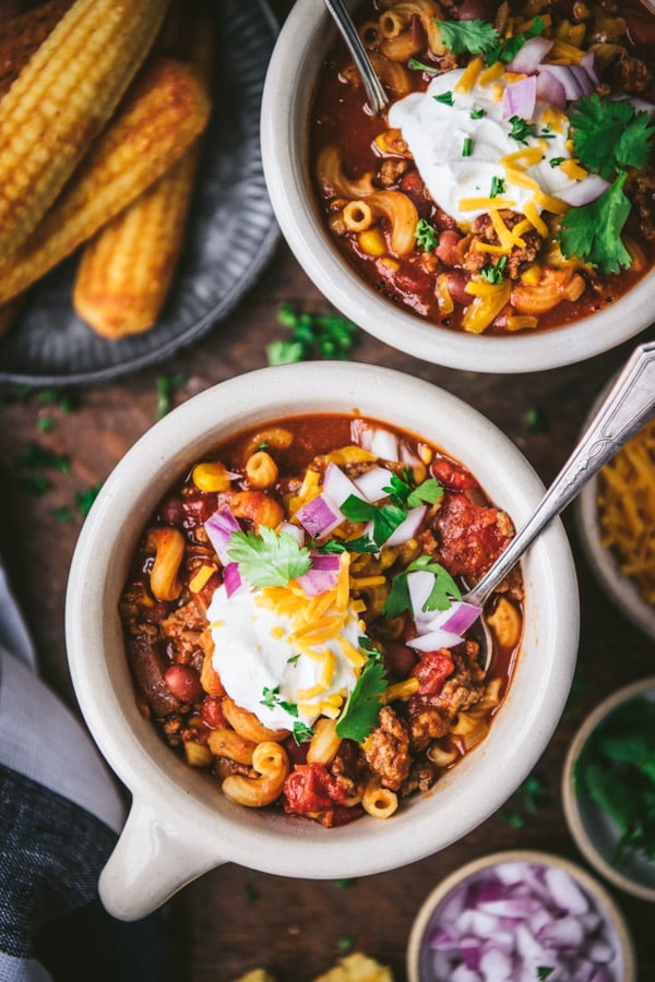 Close overhead shot of chili mac in a bowl with sour cream and cheese on top