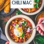 Overhead shot of hands eating a bowl of chili mac with text title overlay