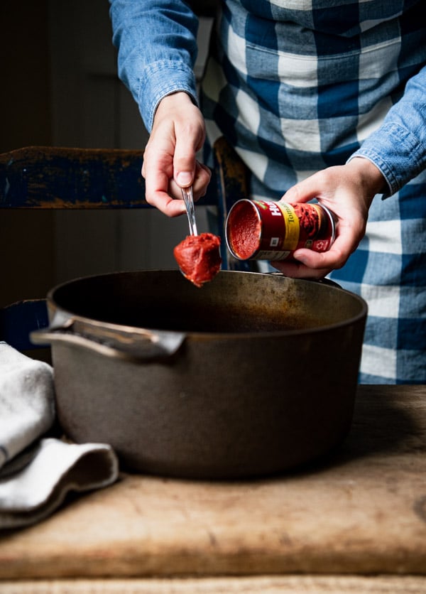 Adding tomato paste to a pot