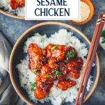 Overhead image of homemade sesame chicken in a bowl with rice and text title overlay