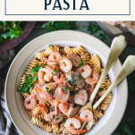 Close overhead image of a bowl of shrimp and sausage pasta with text title box at top