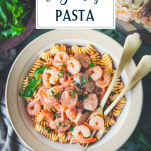 Close overhead shot of a bowl of shrimp and sausage pasta with text title overlay