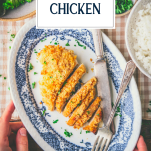 Hands holding a plate of sour cream chicken with text title overlay