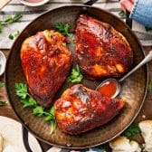 Square overhead shot of oven bbq chicken breast in a cast iron pan.