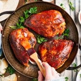 Brushing bbq sauce on baked bbq chicken breast.