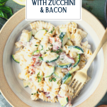 Cheesy pasta with zucchini in a bowl with text title overlay