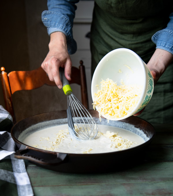 Making cheesy pasta sauce in a skillet