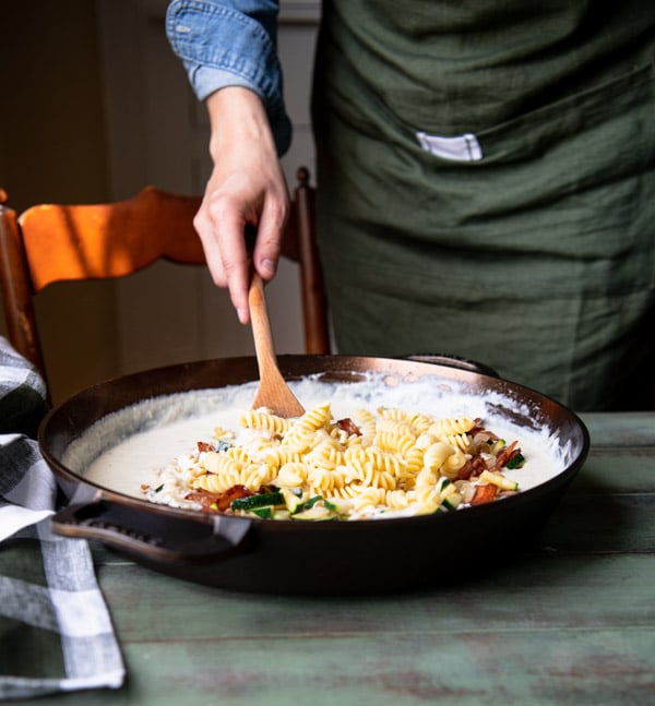Stirring together super cheesy pasta in a cast iron skillet