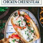 Overhead image of a platter of chicken cheesesteak with text title box at top