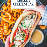 Hands holding a philly chicken cheesesteak with text title overlay
