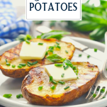 Side shot of grilled potatoes on a white plate with butter and chives and text title overlay