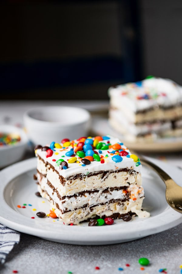 Two plates of ice cream sandwich cake on white plates with gold forks