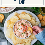 Dipping cracker in shrimp dip with text title box at top