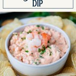 Close up side shot of shrimp dip in a white bowl with text title box at top